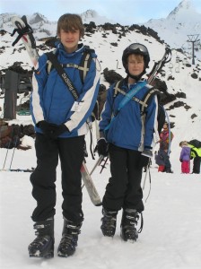 Children carrying skis using SkiSLing ski carriers